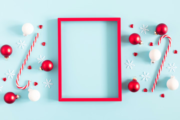 Christmas holiday composition. Red photo frame, Xmas decorations on pastel blue background....