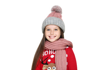 Little girl in christmas sweater, hat and scarf isolated on white background