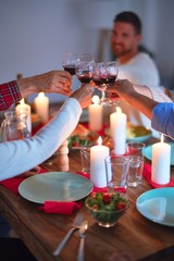 Beautiful family smiling happy and confident. Eating roasted turkey and toasting with cup of wine celebrating Thanksgiving Day at home