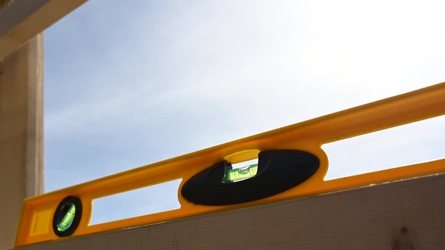 yellow bubble level checking wooden construction sky background