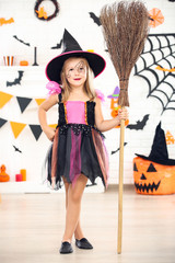 Young girl in halloween costume holding broom
