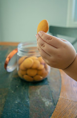 Child's hand picking a cookie