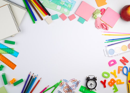 school supplies: multicolored wooden pencils, paper stickers, paper clips, pencil sharpener