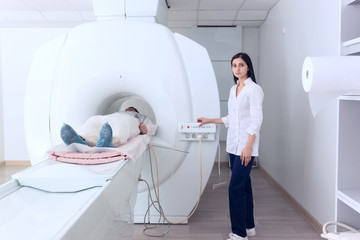 Radiologic technician and man patient lying on a CT Scan bed. preparing for MRI magnetic resonance...