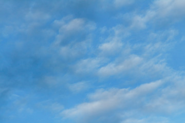 Blue sky with cirrus clouds. Sun flare below.