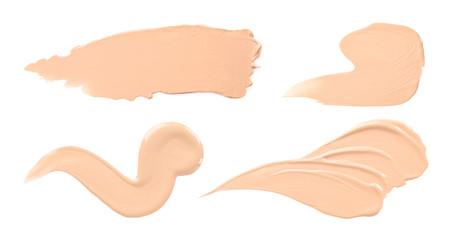 Set with samples of liquid foundation on white background, top view