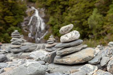 Pile of rocks that mark the way for hikers along a river.