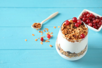 Tasty homemade granola served on blue wooden table, space for text. Healthy breakfast
