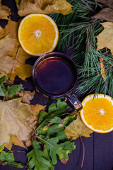 Autumn tea with orange on the background of leaves