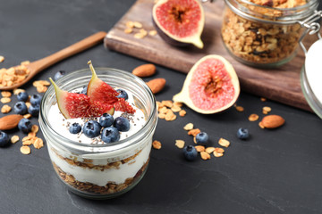 Tasty homemade granola dessert on dark grey table. Healthy breakfast