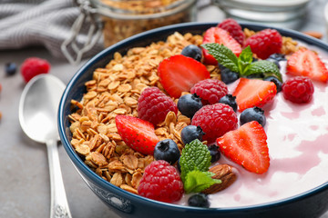 Tasty homemade granola with yogurt on grey table, closeup. Healthy breakfast