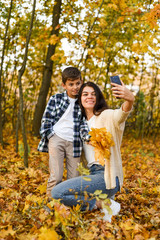 Fototapeta premium mom and son take selfies in the autumn forest. copy space