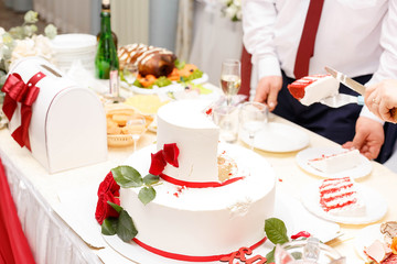 cutting wedding cake decorated with roses