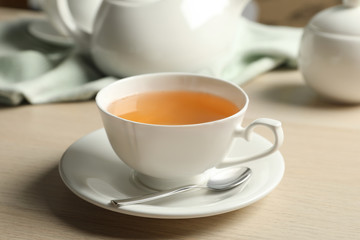 Cup of hot green tea on wooden table