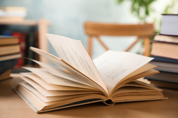 Open hardcover book on wooden table indoors