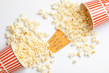 Popcorn and tickets on white background, top view. Cinema snack