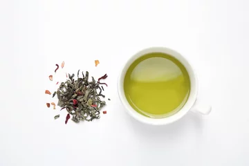 Fotobehang Green tea leaves and cup of hot beverage on white background, flat lay © New Africa