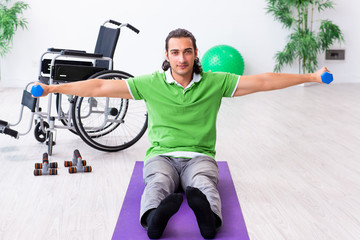 Young man in wheel-chair doing exercises indoors