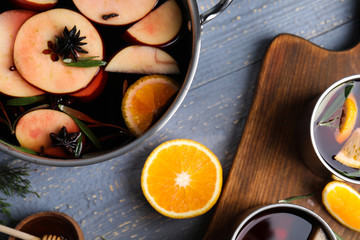 Fototapeta na wymiar Tasty mulled wine with spices on grey wooden table, flat lay