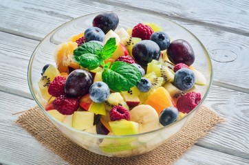 Fresh colorful fruit. Salad of various fruits on a wooden kitchen table.