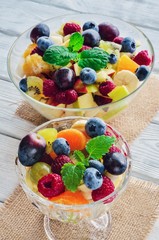 Fresh colorful fruit. Salad of various fruits on a wooden kitchen table.
