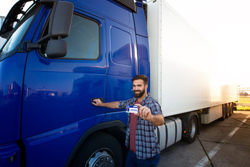 Truck driving school. CDL training for truck drivers. Professional truck driver standing by his...