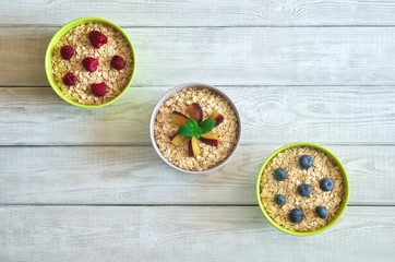 Sweet healthy breakfast. Porridge with plums, raspberries and blueberries.