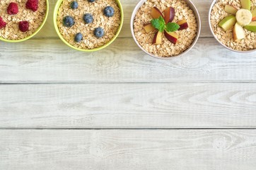 Creative background with healthy food. Different porridge on a wooden white background.