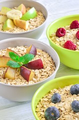 Sweet delicious healthy breakfast. Different porridge with fruit on a wooden kitchen table.
