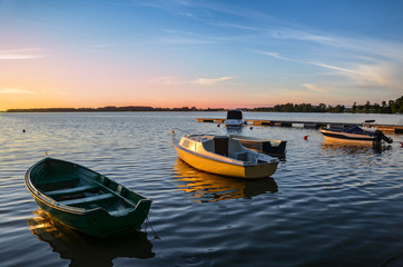 Evening sun over the Kisajno lake and moored boats, Pierkunowo near Gizycko, Masuria, Poland.
