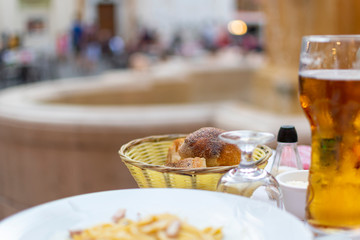 A bread basket of freshly baked rolls on a patio table in a piazza at Place Rossetti on the French Riviera in Nice, France.