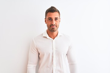 Young handsome business man wearing elegant shirt over isolated background Relaxed with serious expression on face. Simple and natural looking at the camera.