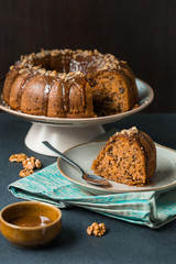 Pumpkin-carrot band cake with walnuts and caramel sauce. Homemade. On dark background.