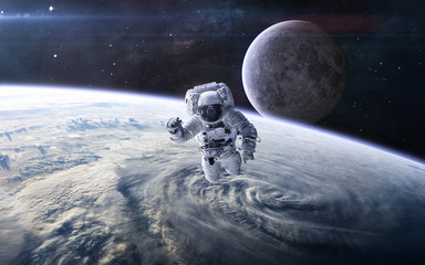 Astronaut in outer space against the background of the Earth's landscape and the Moon. Solar...