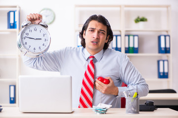 Young male employee suffering in the office