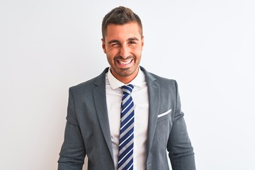 Young handsome business man wearing suit and tie over isolated background winking looking at the camera with sexy expression, cheerful and happy face.