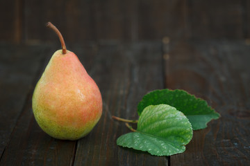 Fresh pear with leaves on wooden background. Organic pear, sweet and healthy fruit.