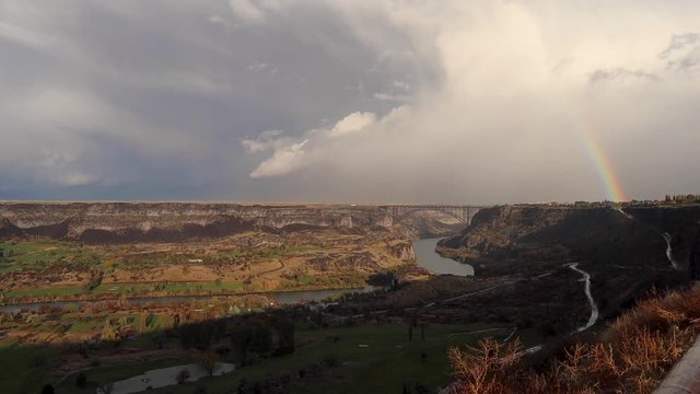 Snake River Canyon, with weather system in the distance and rainbow, handheld wide shot