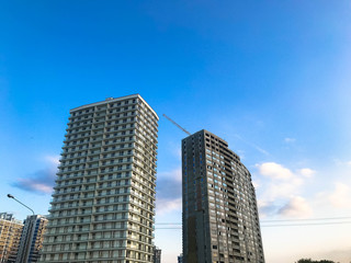 Obraz premium Tall beautiful monolithic-frame panel buildings, new buildings, skyscrapers, houses made of glass and concrete with many windows in the new district of the city. The background
