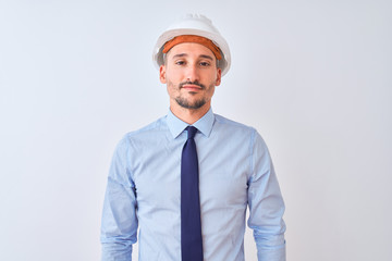 Young business man wearing contractor safety helmet over isolated background Relaxed with serious expression on face. Simple and natural looking at the camera.