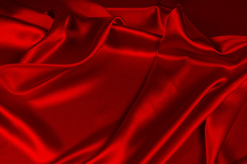 Red silk or satin luxury fabric texture can use as abstract background. Top view.