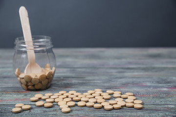 Alternative medicine tablets on a wooden spoon