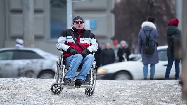 Lonely disabled person in a wheelchair on the road in a big city.  Health problems.