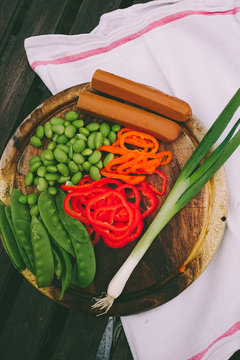 Lima beans, spring onion, tofu, mange tout and peppers on a chopping board