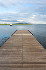 Wooden pier on sunny summer day with boats and forest in the background on Rio Tapajos, Para state, Brazil. Concept of leisure, vacation, travel, tourism and mindfulness.