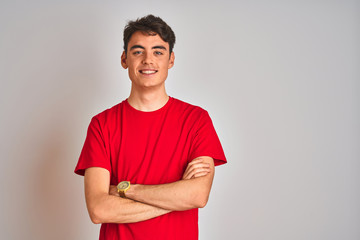 Teenager boy wearing red t-shirt over white isolated background happy face smiling with crossed...