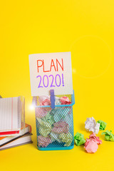 Handwriting text writing Plan 2020. Conceptual photo detailed proposal doing achieving something next year Trash bin crumpled paper clothespin empty reminder office supplies yellow