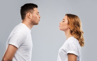 love, valentines day and relationships concept - portrait of happy couple in white t-shirts ready for kiss over grey background