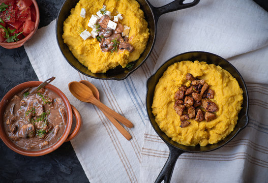 Traditional Eastern European corn mush (mamaliga, polenta, banosh, balmes) topped with sheep cheese, mushroom gravy, fried meat pieces