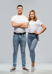 relationships and people concept - portrait of happy couple in white t-shirts over grey background